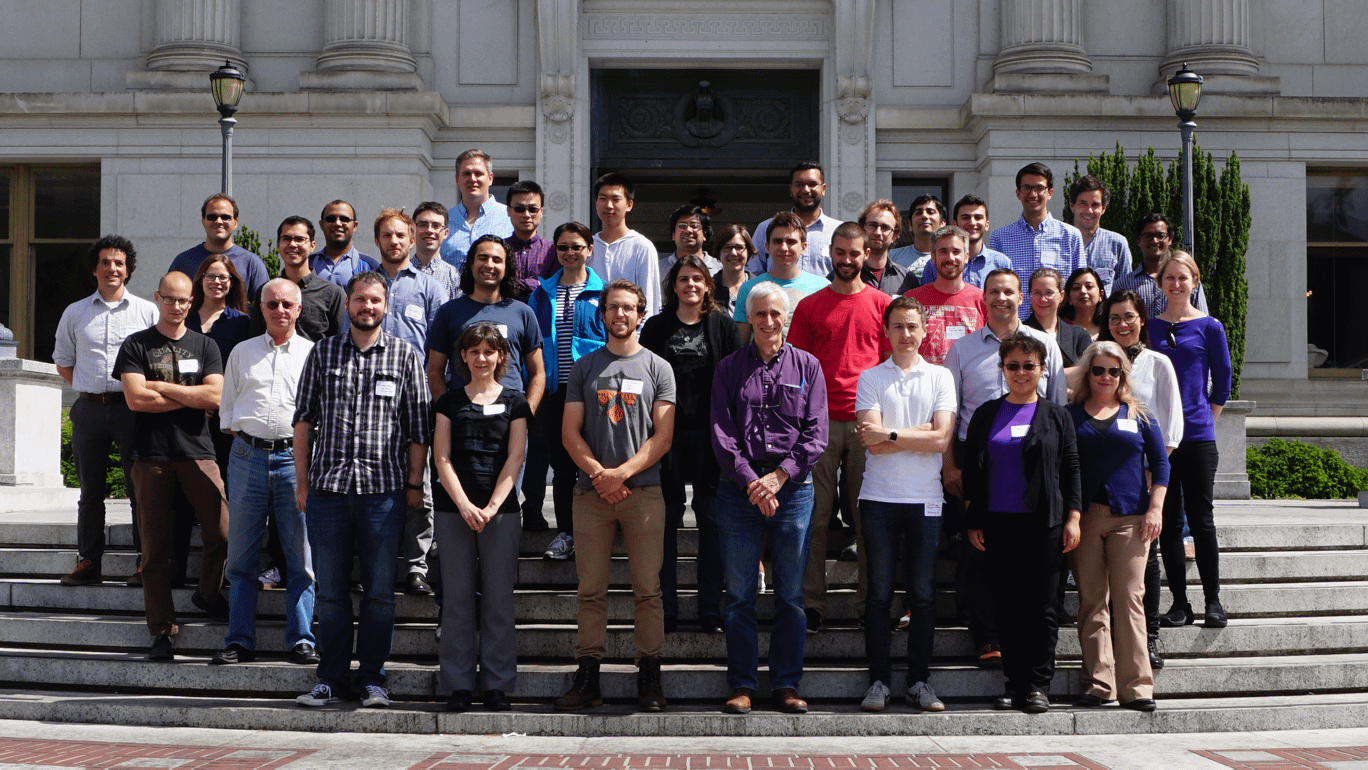 A group of people stand formally in front of a building